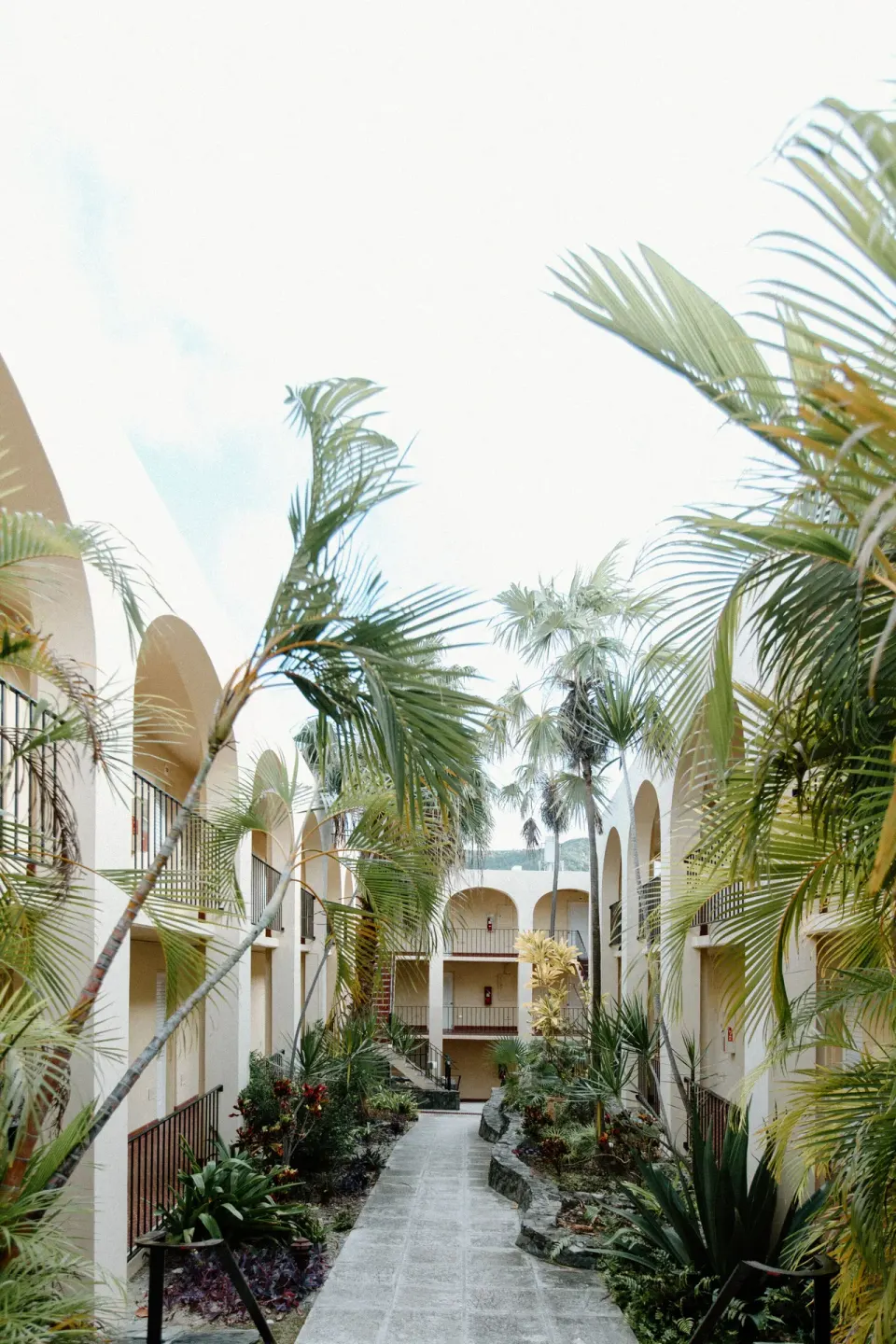 Tropical courtyard walkway between arched hotel buildings at Hotel on the Cay.