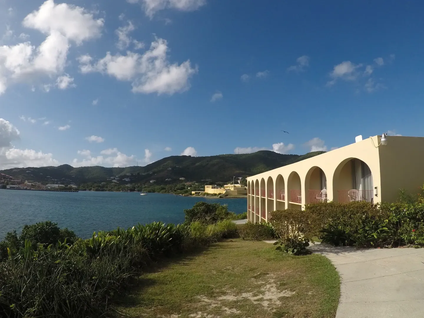 Arched guestroom building beside the water and gardens at Hotel on the Cay.