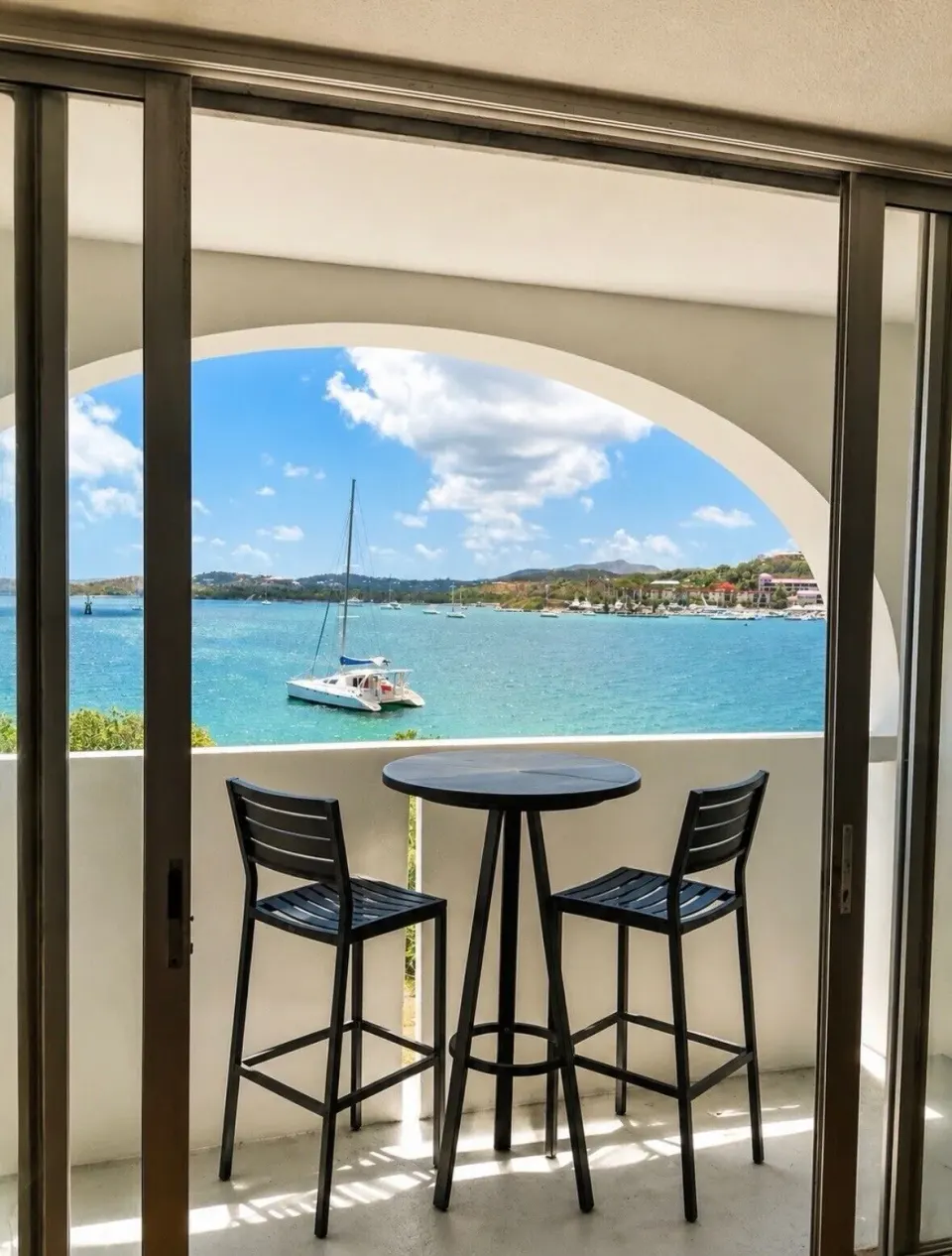 Private balcony with table, chairs, and bay view at Hotel on the Cay.