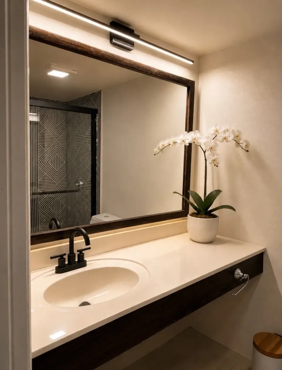 Deluxe room bathroom vanity with mirror, sink, and orchid at Hotel on the Cay.