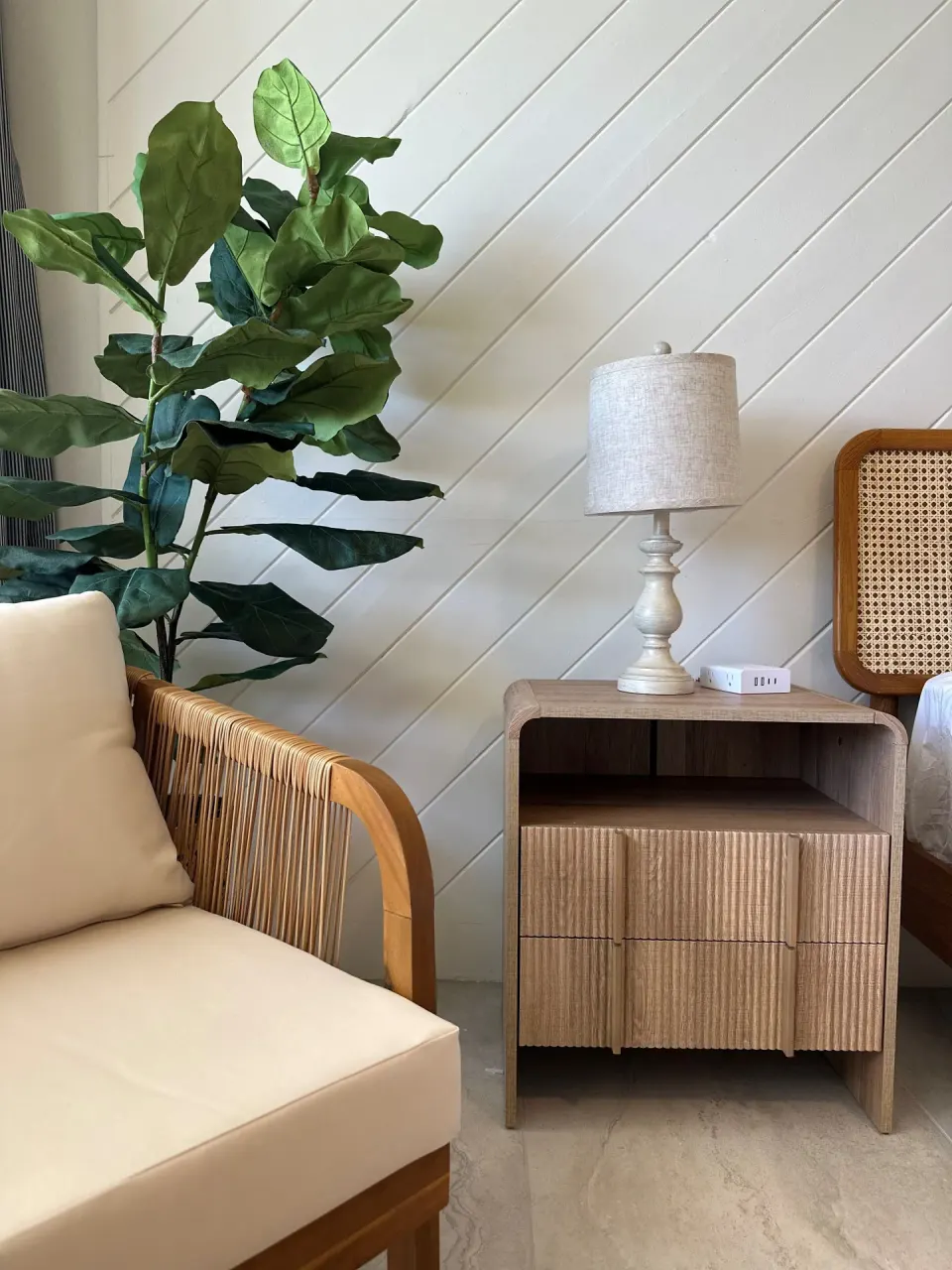 Deluxe room chair, bedside table, lamp, and partial bed at Hotel on the Cay.