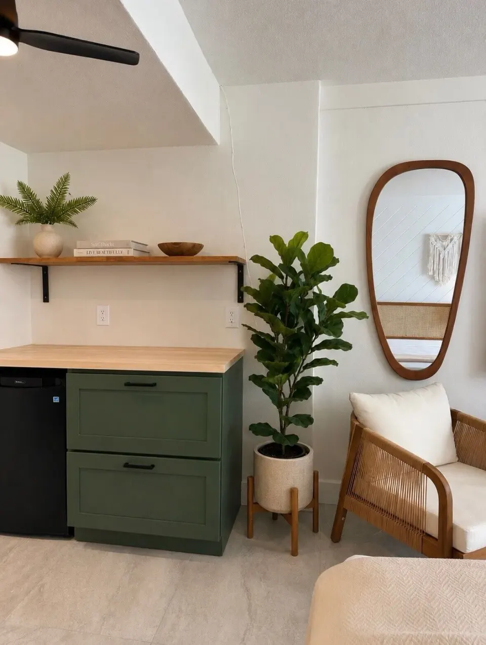 Deluxe room kitchenette, mirror, chair, and plants at Hotel on the Cay.