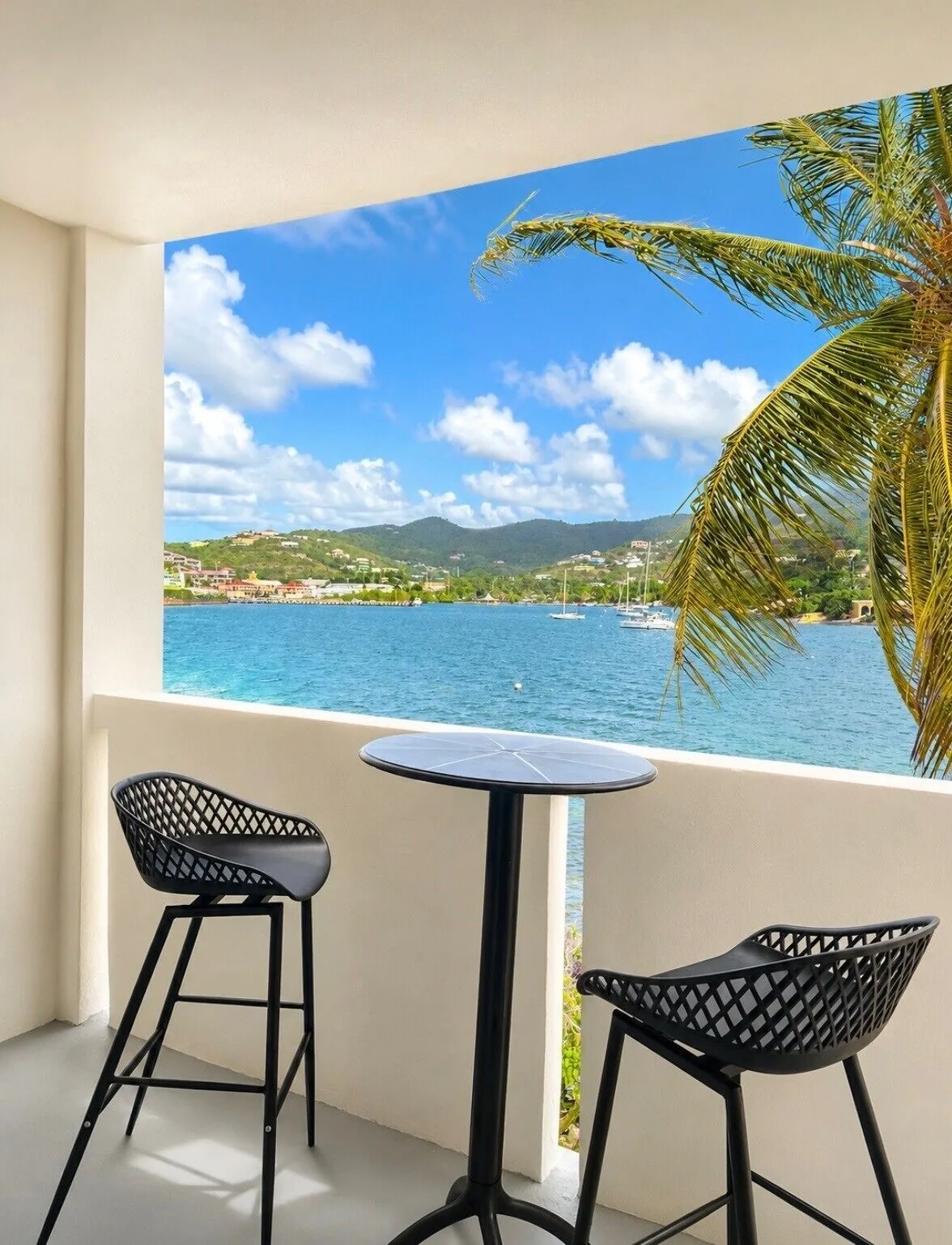 Deluxe Room balcony facing harbor water and hills at Hotel on the Cay.