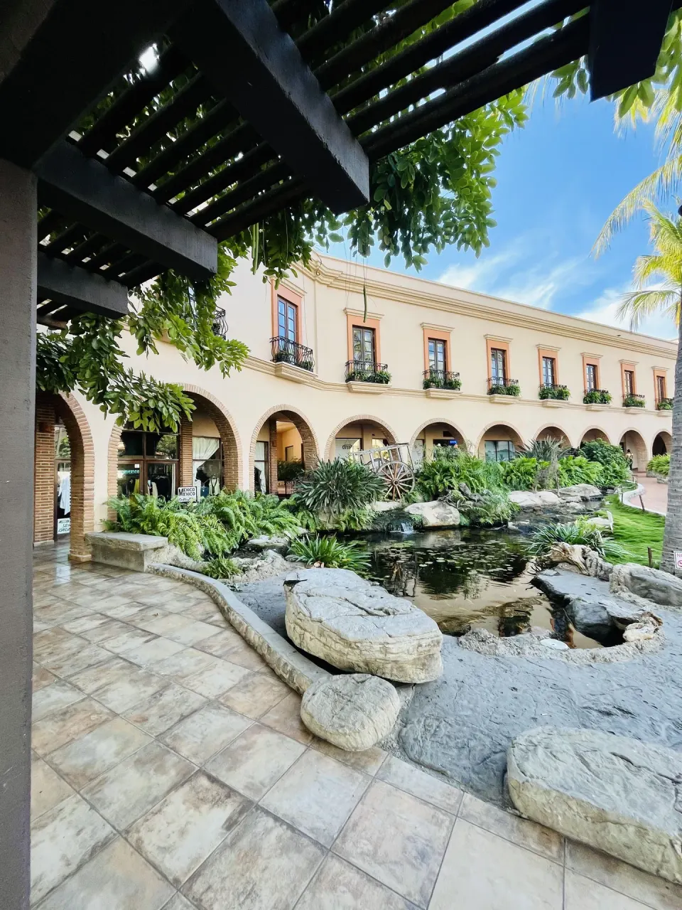 Arched courtyard, pond, and garden walkway at Hotel Playa Mazatlan.