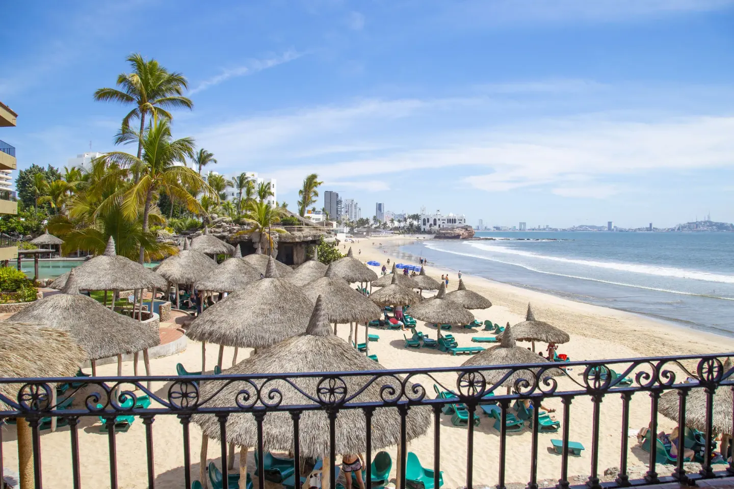 Beach palapas and lounge chairs along the shoreline at Hotel Playa Mazatlan.