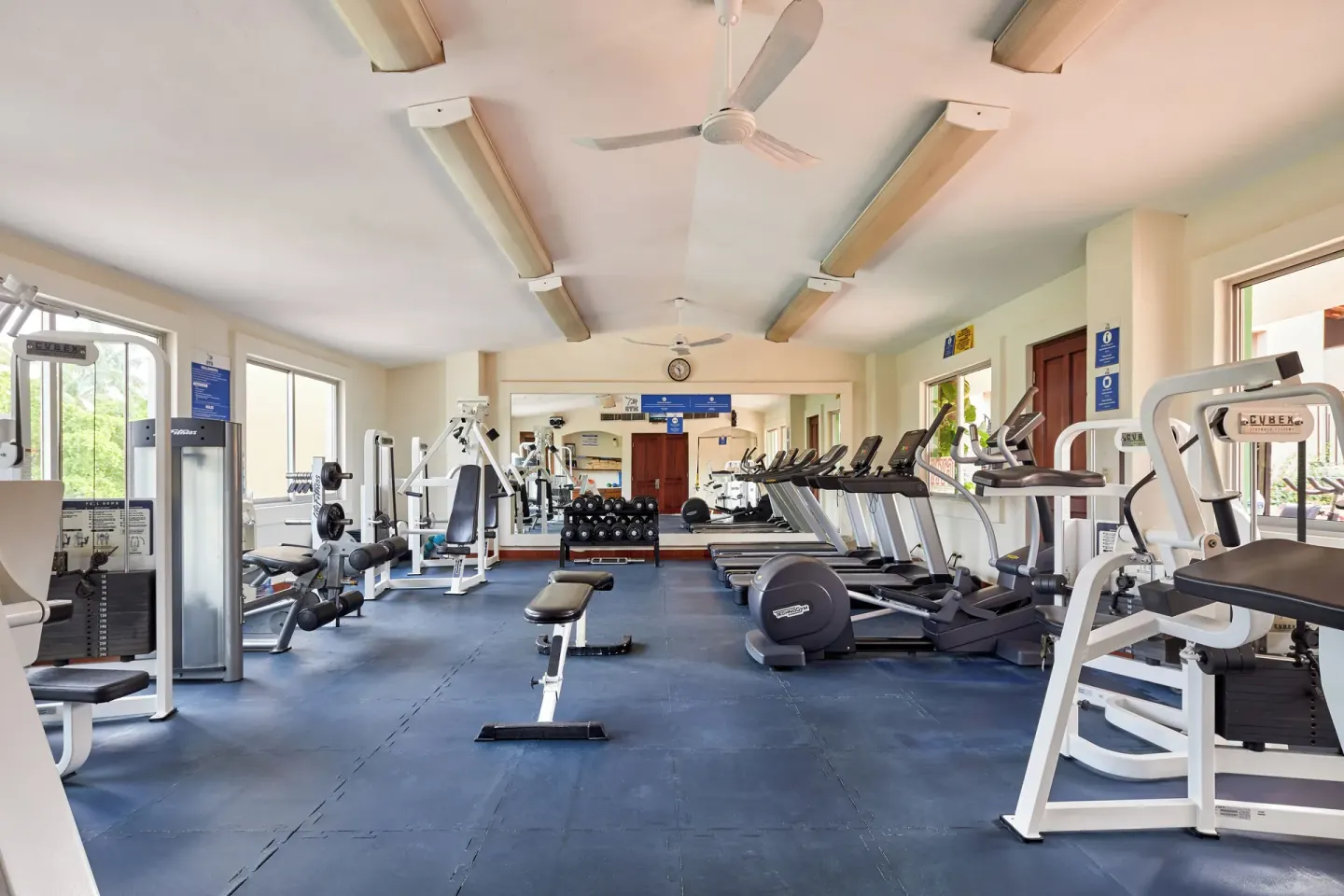 Bright fitness room with cardio machines, benches, and strength equipment at Hotel Playa Mazatlan.