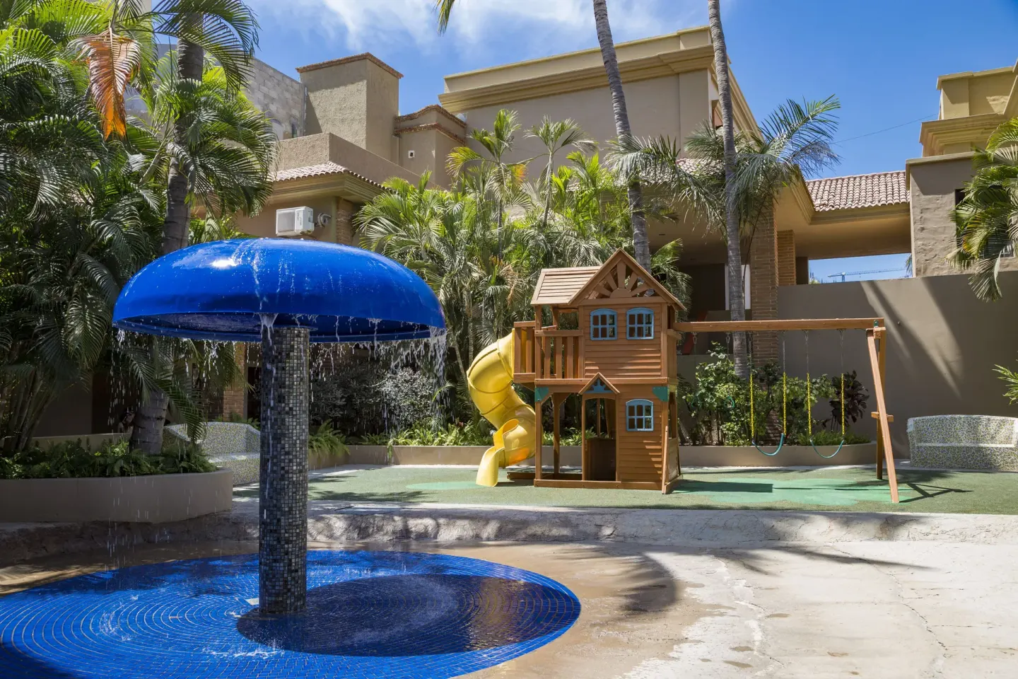 Children's splash area with mushroom fountain, slide and playhouse at Hotel Playa Mazatlan.