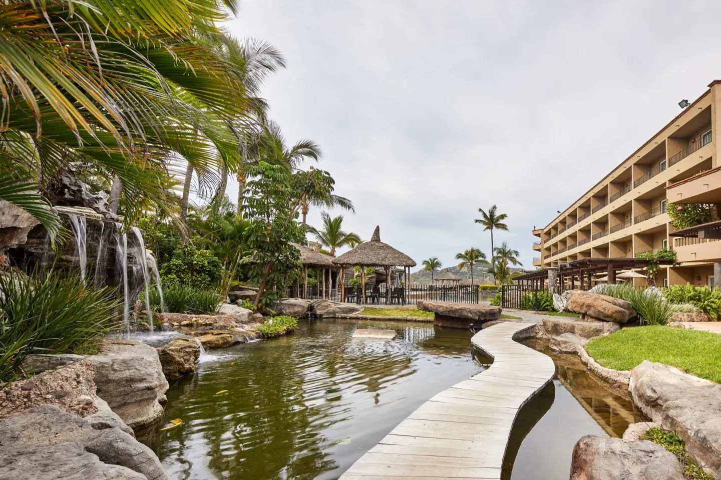 Lagoon garden with waterfall and curved walkway at Hotel Playa Mazatlan.