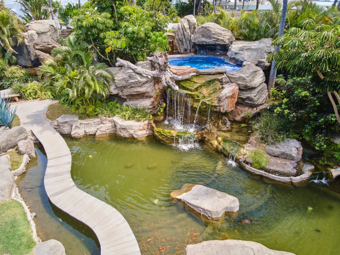 Overhead view of a garden pond, waterfall, and blue pool at Hotel Playa Mazatlan.