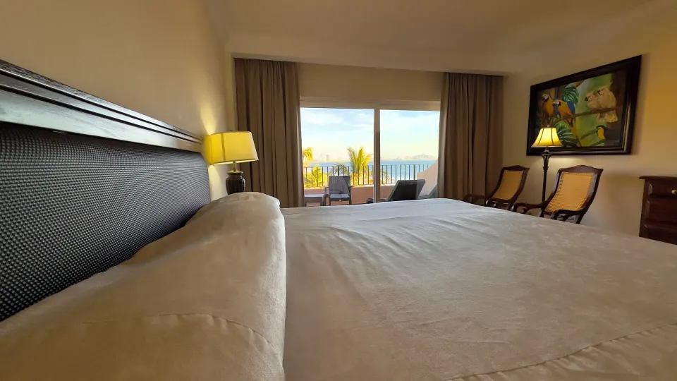 One-bed guest room looking from the headboard toward the balcony at Hotel Playa Mazatlan.