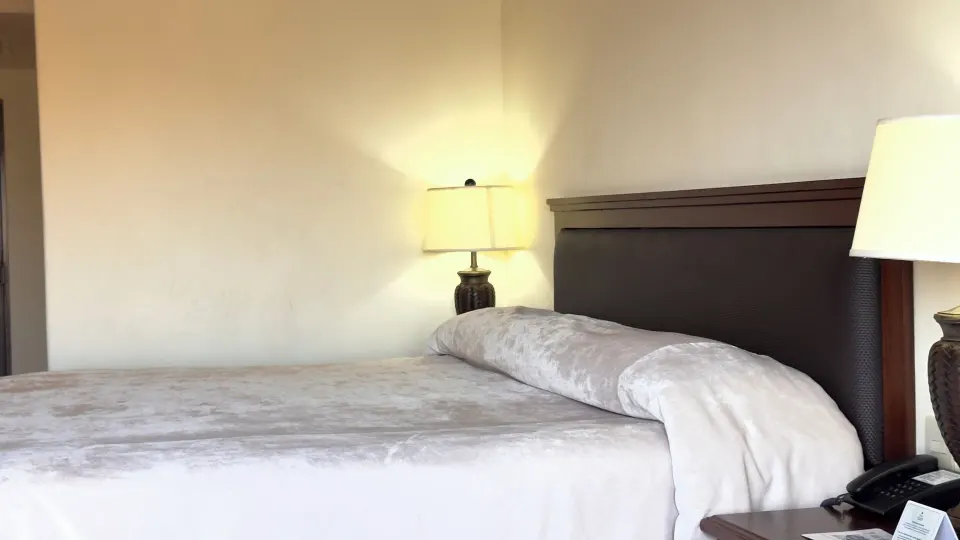 Close view of a one-bed guest room with lamps and nightstand at Hotel Playa Mazatlan.