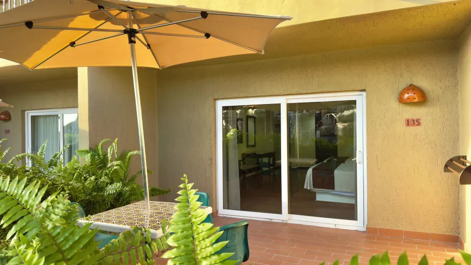 Standard room patio with umbrella and sliding door at Hotel Playa Mazatlan.