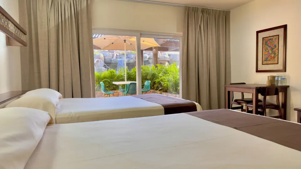 Standard room with two beds and patio doors at Hotel Playa Mazatlan.