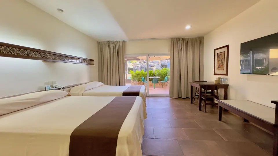 Standard room with two beds, TV, and patio view at Hotel Playa Mazatlan.