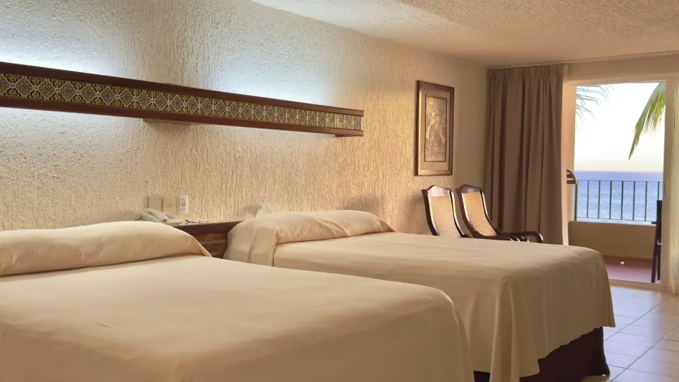 Two-bed room with balcony and ocean beyond at Hotel Playa Mazatlan.