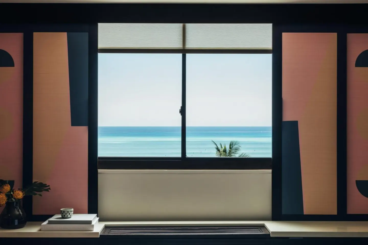 Ocean view through a Hotel Renew guest room window with graphic side panels.