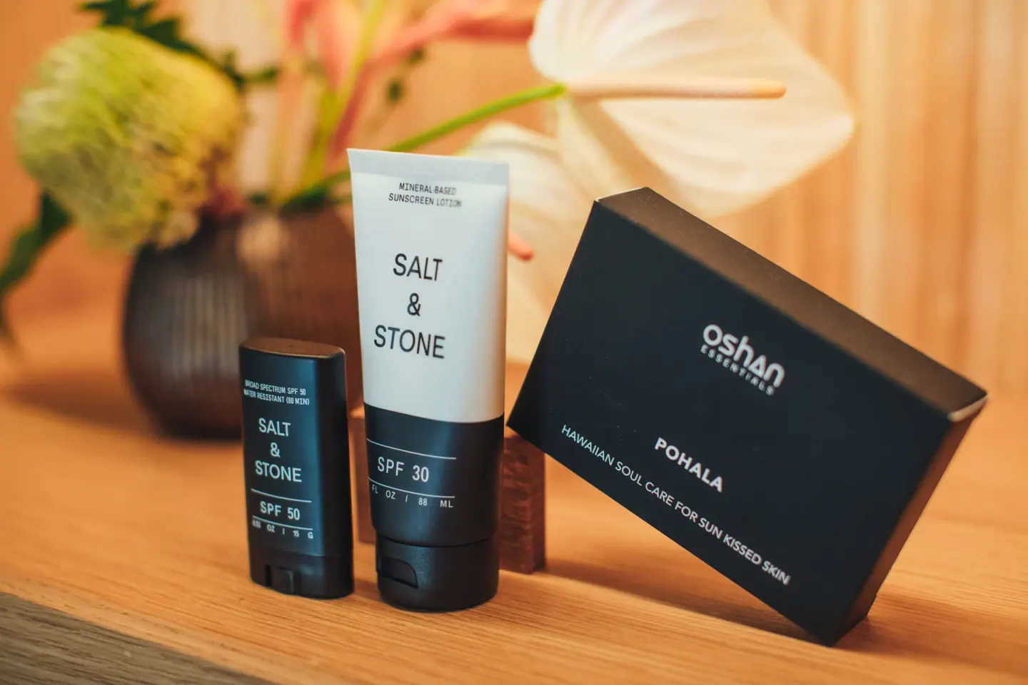 Sunscreen and skincare items are displayed with flowers at Hotel Renew.