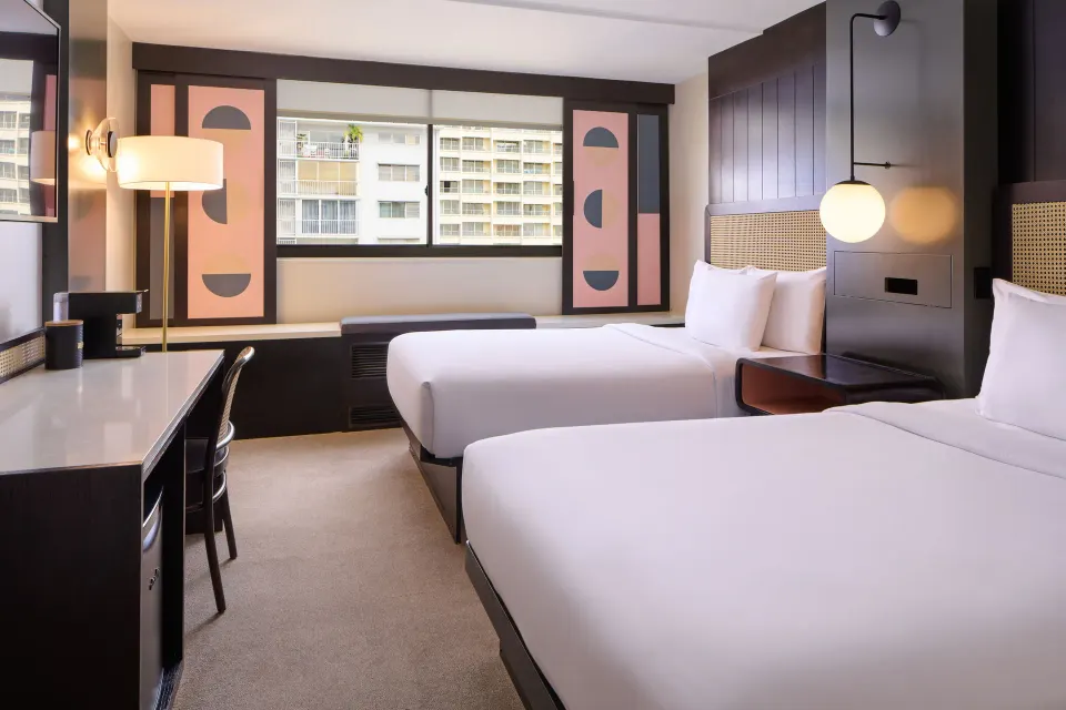 City View room at Hotel Renew with two full beds, desk, window bench, and neighboring buildings outside.