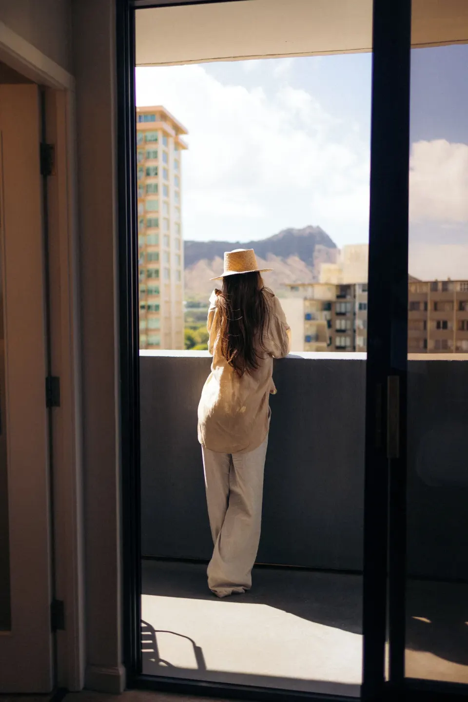 Guest standing on the balcony of a Corner Ocean View room at Hotel Renew.