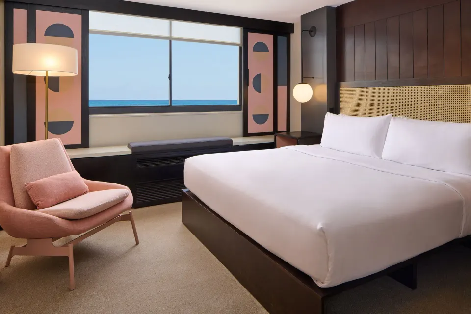 Corner Ocean View guest room with king bed and ocean-facing window at Hotel Renew.