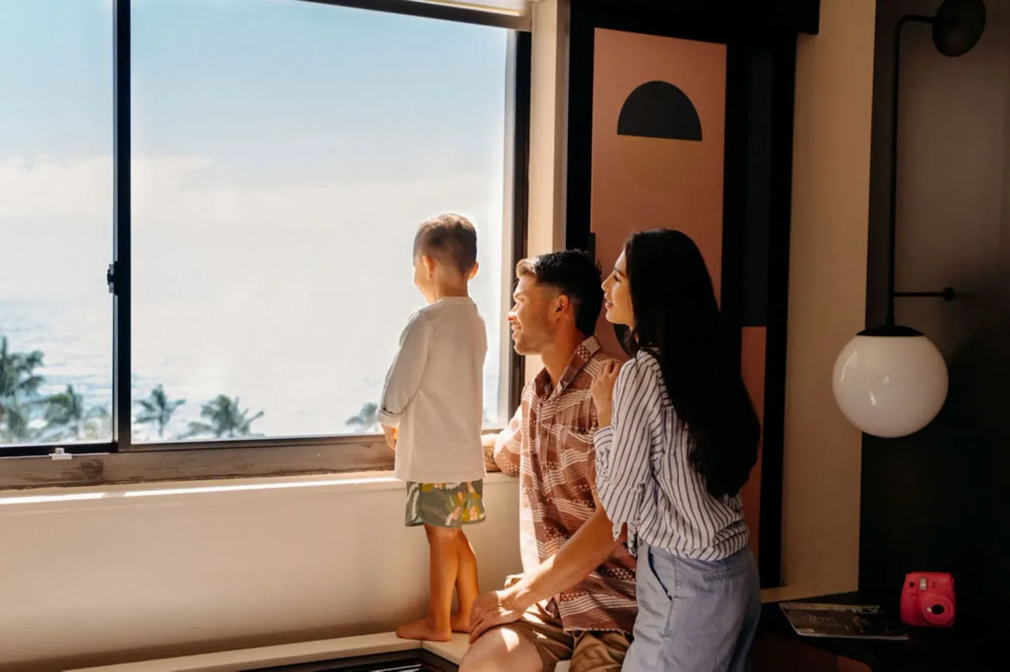 Family looks out from an Ocean View Room window at Hotel Renew.