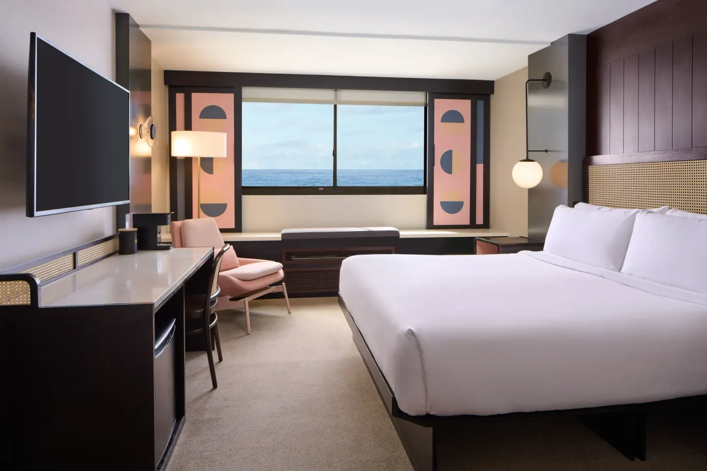 Ocean View guest room with king bed, desk, TV, and sea-facing window at Hotel Renew.