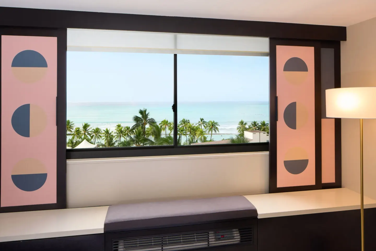 Ocean View room window with palm trees, beach, and water visible at Hotel Renew.