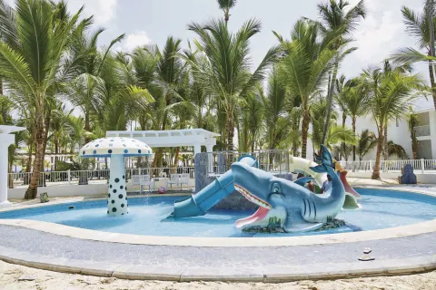 Children’s splash pool with shark slide and mushroom fountain at Hotel Riu Bambu.