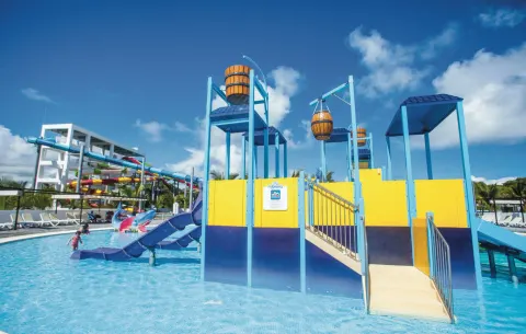 Children's splash pool with slides and dump buckets at Hotel Riu Bambu.