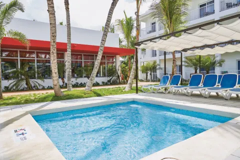 Small square whirlpool with blue loungers and shade canopy at Hotel Riu Bambu.