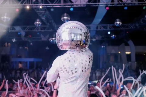 Disco-ball performer facing a party crowd at Hotel Riu Cancun.