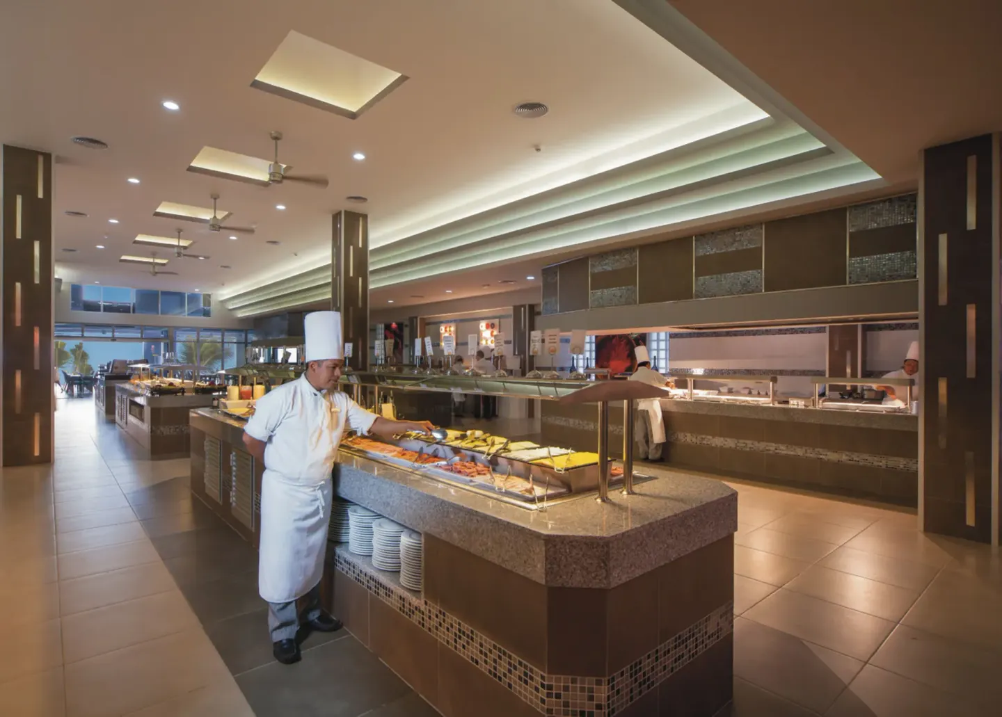 Buffet counter with a chef and serving stations at Hotel Riu Cancun.