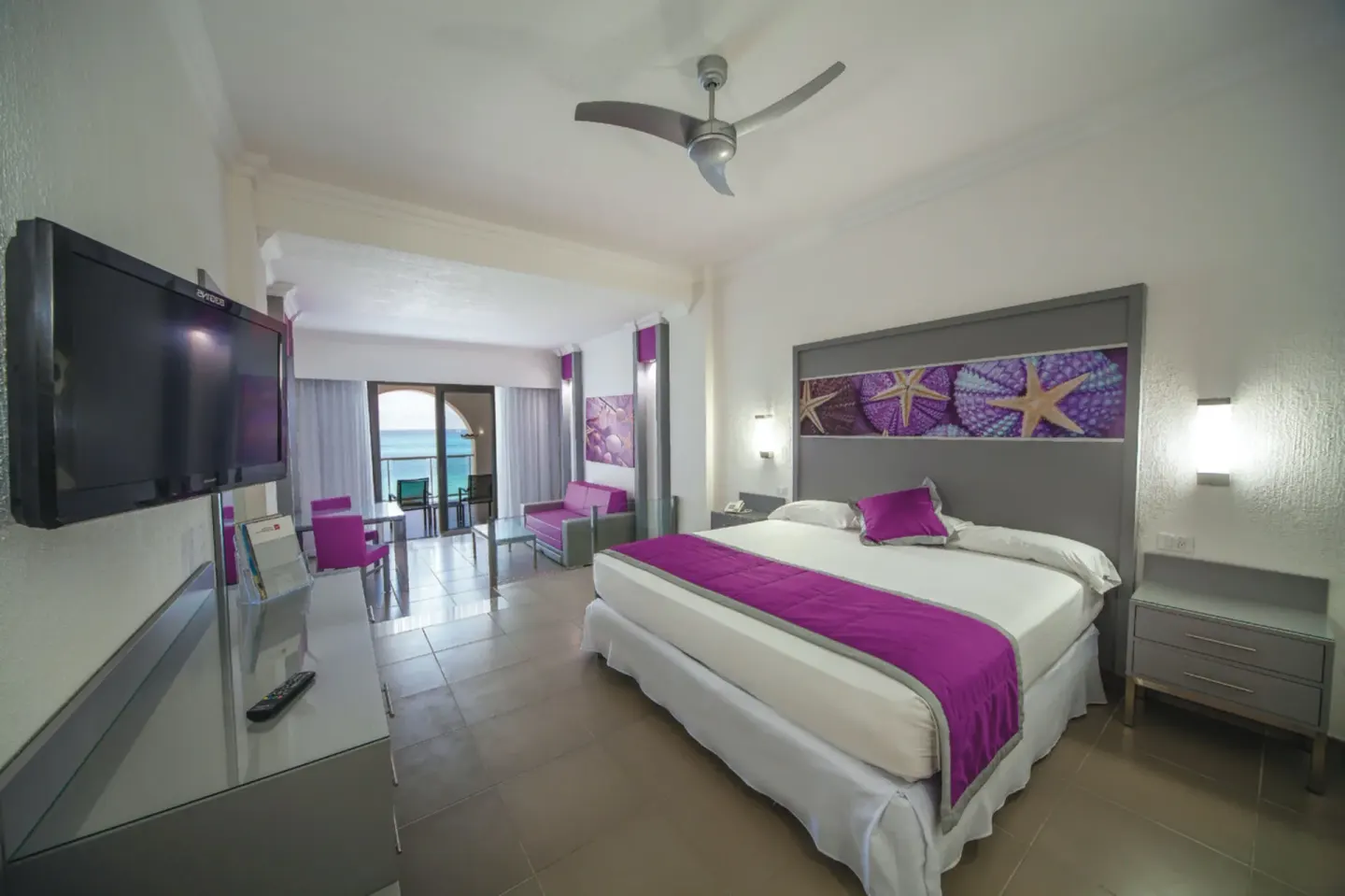 Junior Suite Ocean View guest room with king bed and balcony at Hotel Riu Cancun.