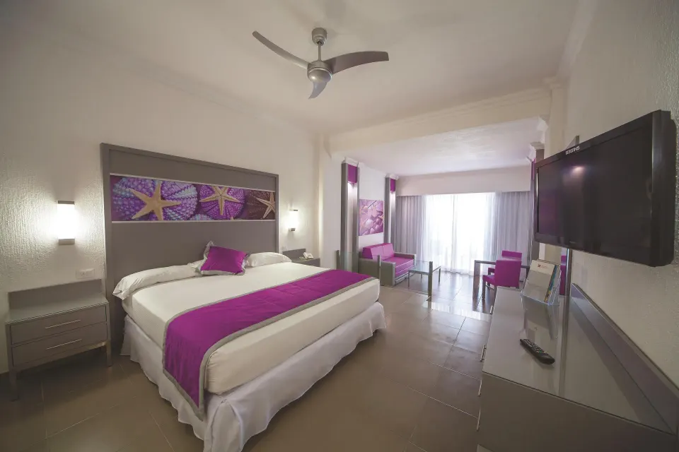 Junior Suite Ocean View with king bed and seating area at Hotel Riu Cancun.