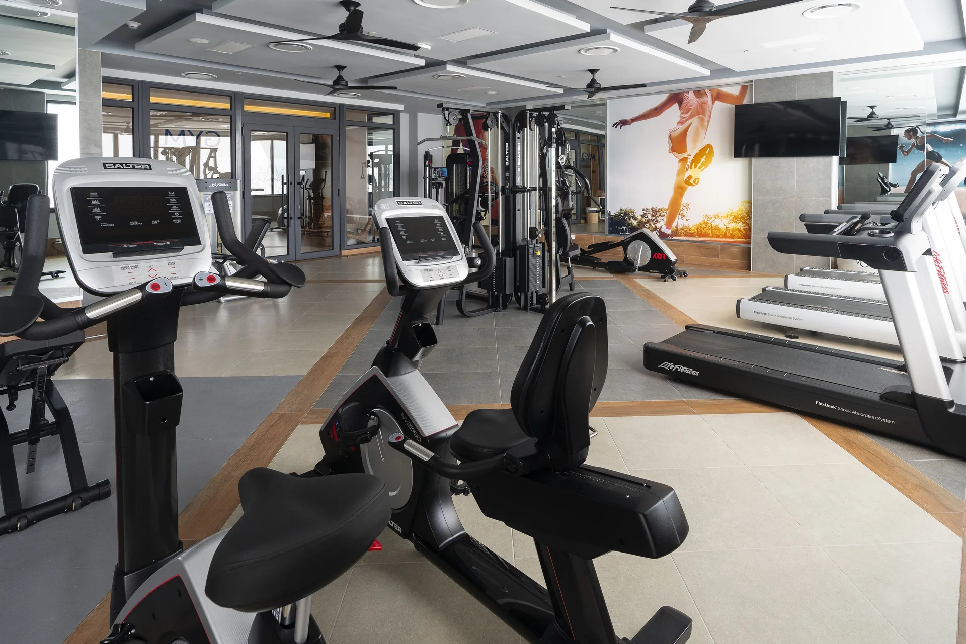 Fitness room with cardio machines, treadmills, and weight equipment at Hotel Riu Caribe.