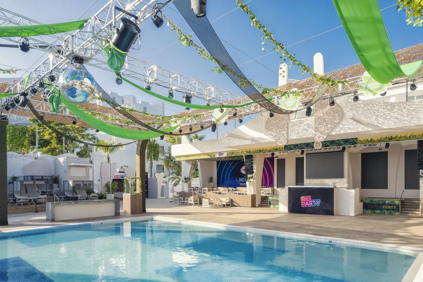 Poolside stage with green shade fabric and lighting at Hotel Riu Caribe.