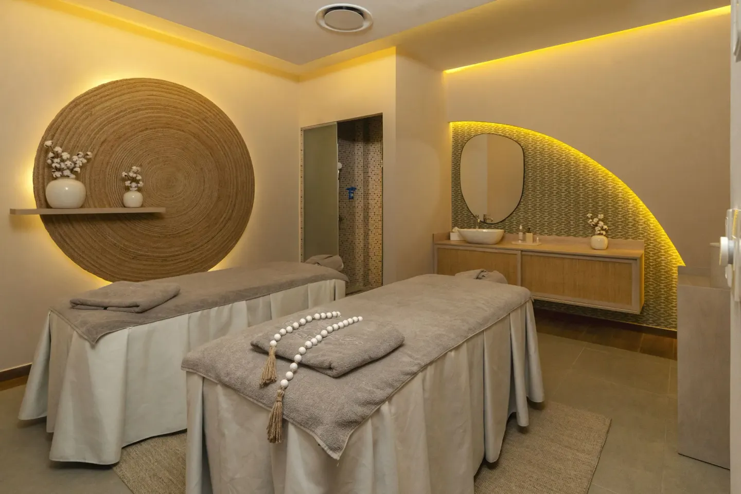 Spa treatment room with two massage tables and warm lighting at Hotel Riu Caribe.