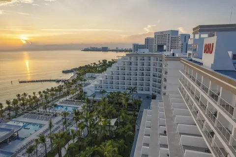 Sunset over the water beside the balconies and pools of Hotel Riu Caribe.