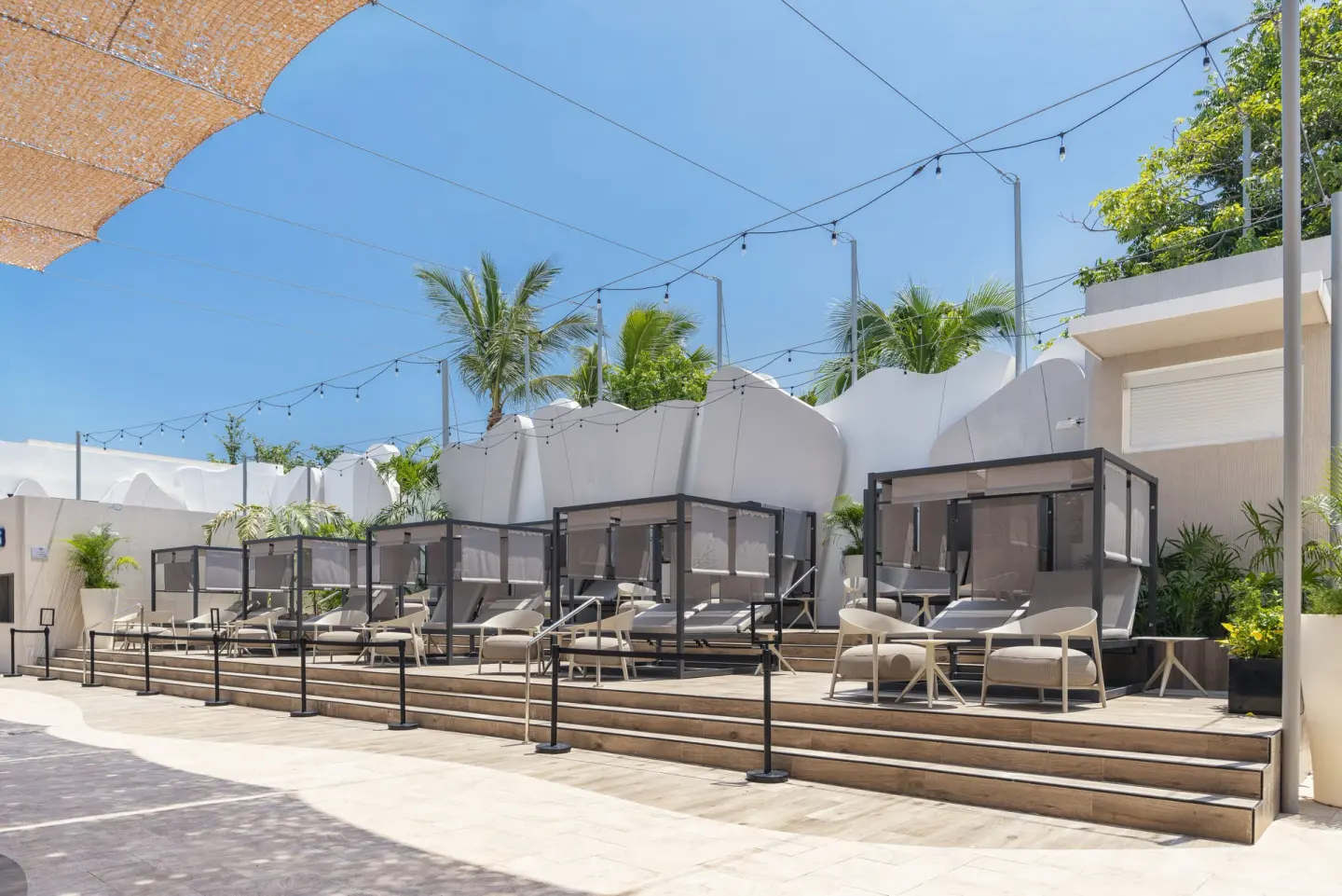 Shaded cabanas and lounge chairs on a terrace at Hotel Riu Caribe.