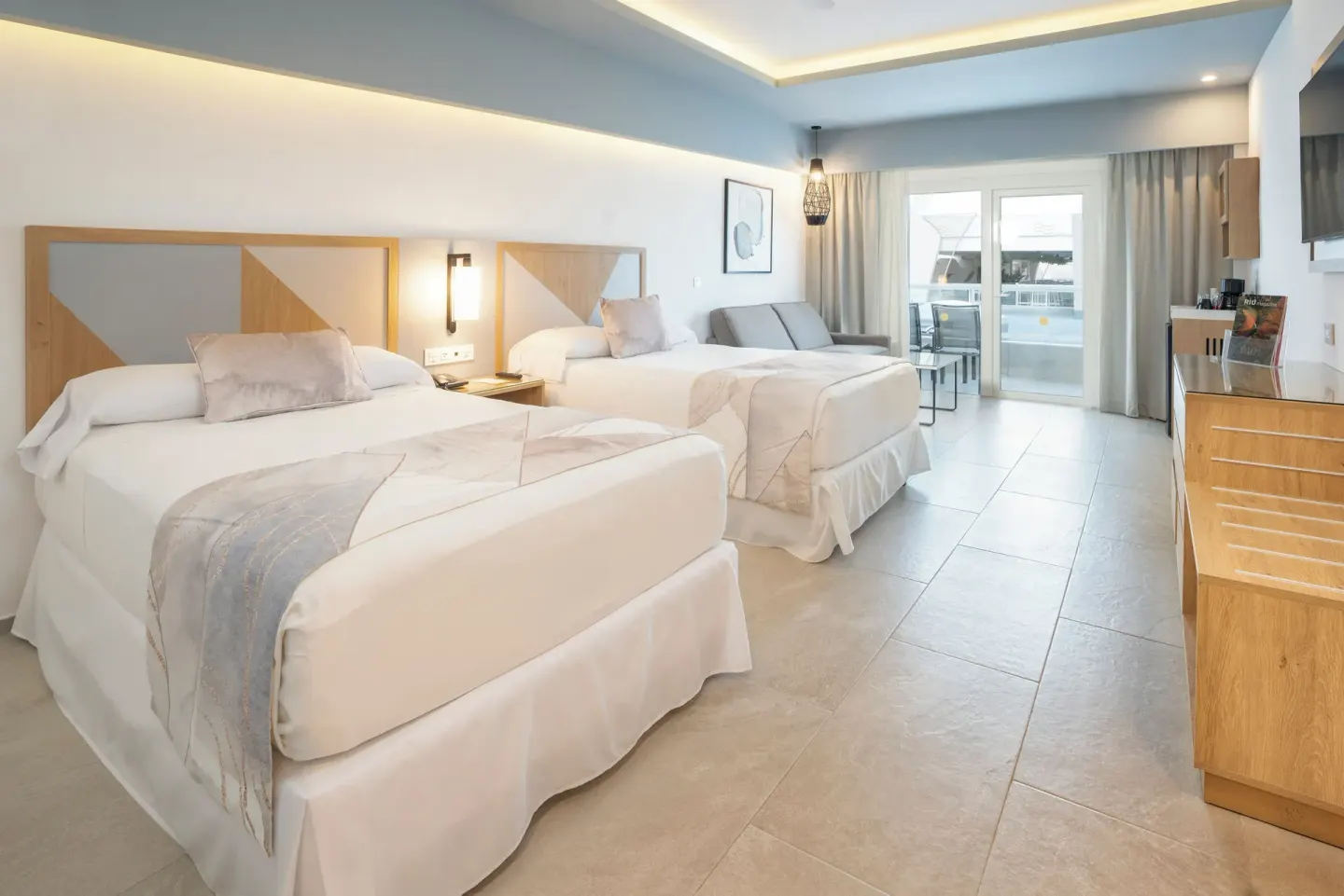 Two-bed Hotel Riu Caribe guest room with balcony seating at Hotel Riu Caribe.