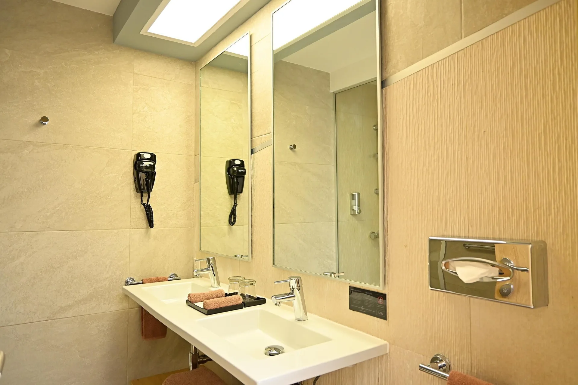 Guest bathroom vanity with double sinks and mirrors at Hotel Riu Caribe.