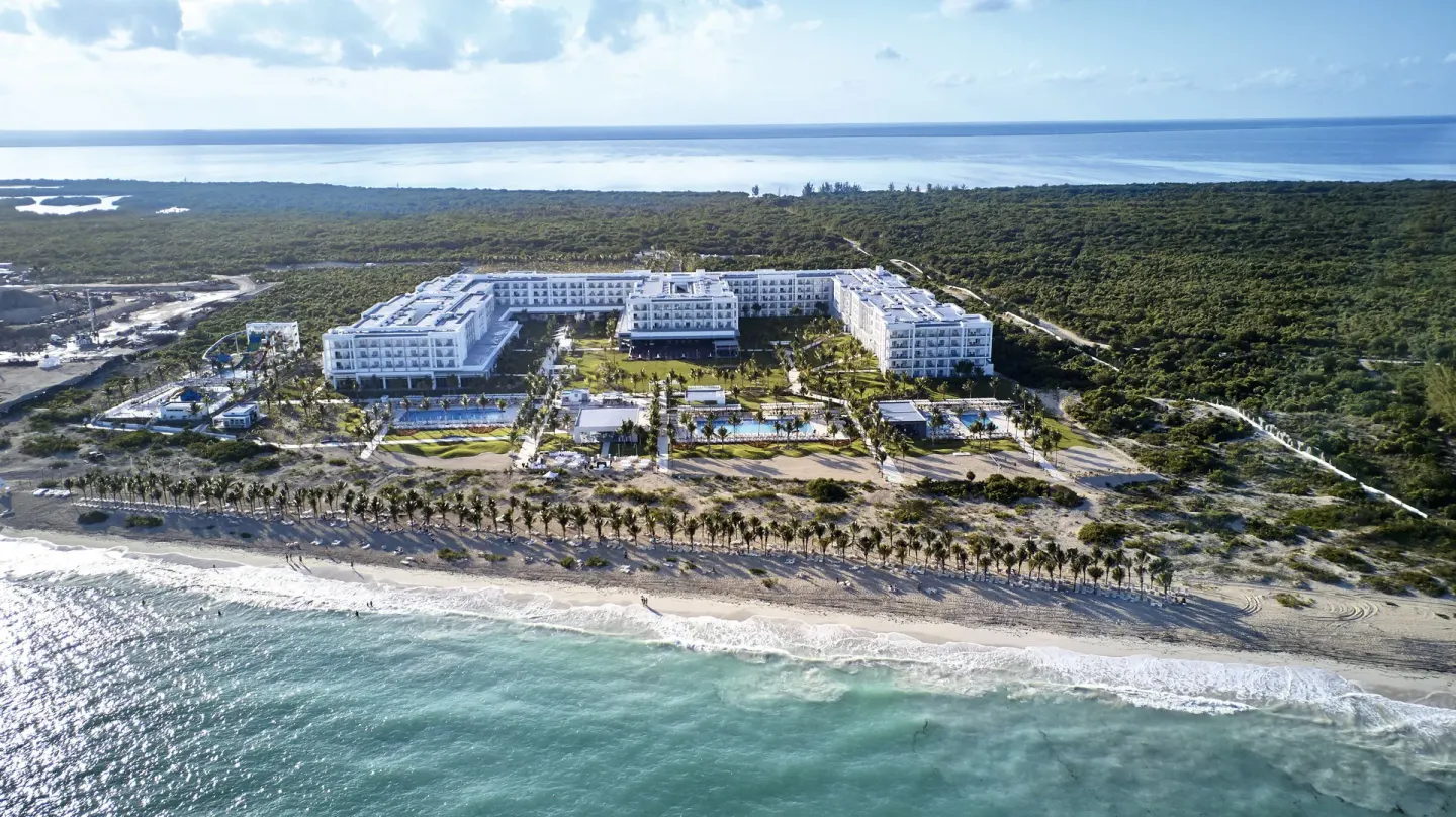 Aerial beachfront view of Hotel Riu Dunamar with pools, palms, beach, and sea.