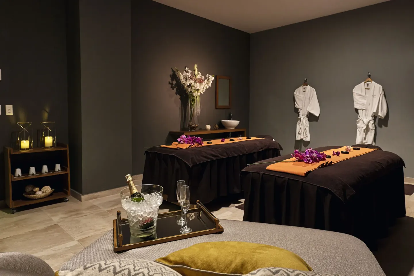 Spa treatment room with two massage tables and robes at Hotel Riu Dunamar.