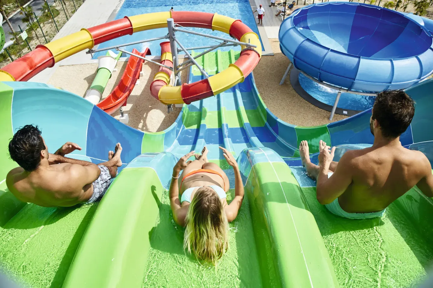Guests starting down bright green waterslides at Hotel Riu Dunamar.