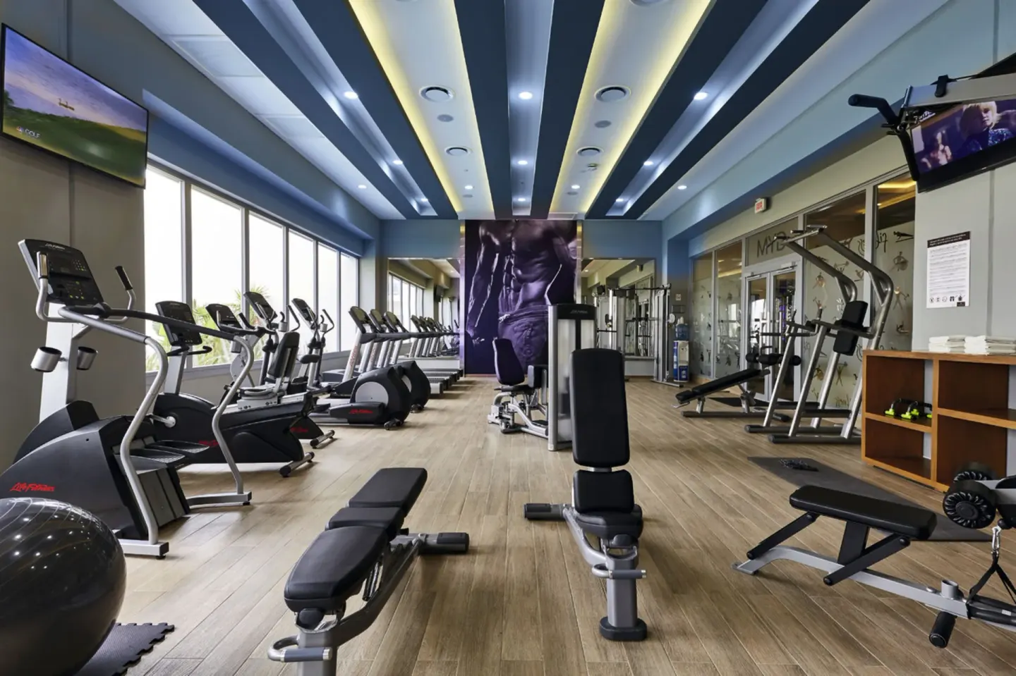 Indoor fitness room with cardio machines and weights at Hotel Riu Dunamar.