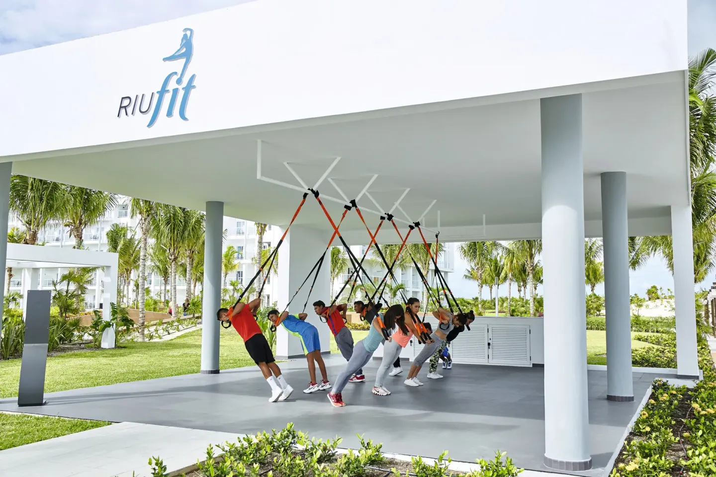 Outdoor suspension training class under a fitness pavilion at Hotel Riu Dunamar.