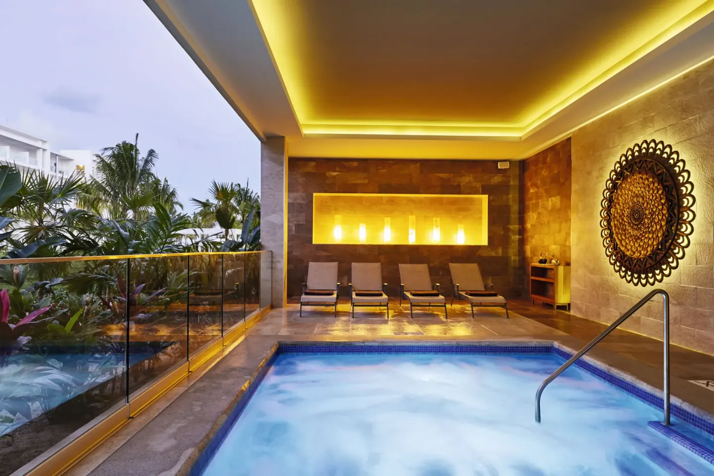 Spa whirlpool with loungers and warm lighting at Hotel Riu Dunamar.