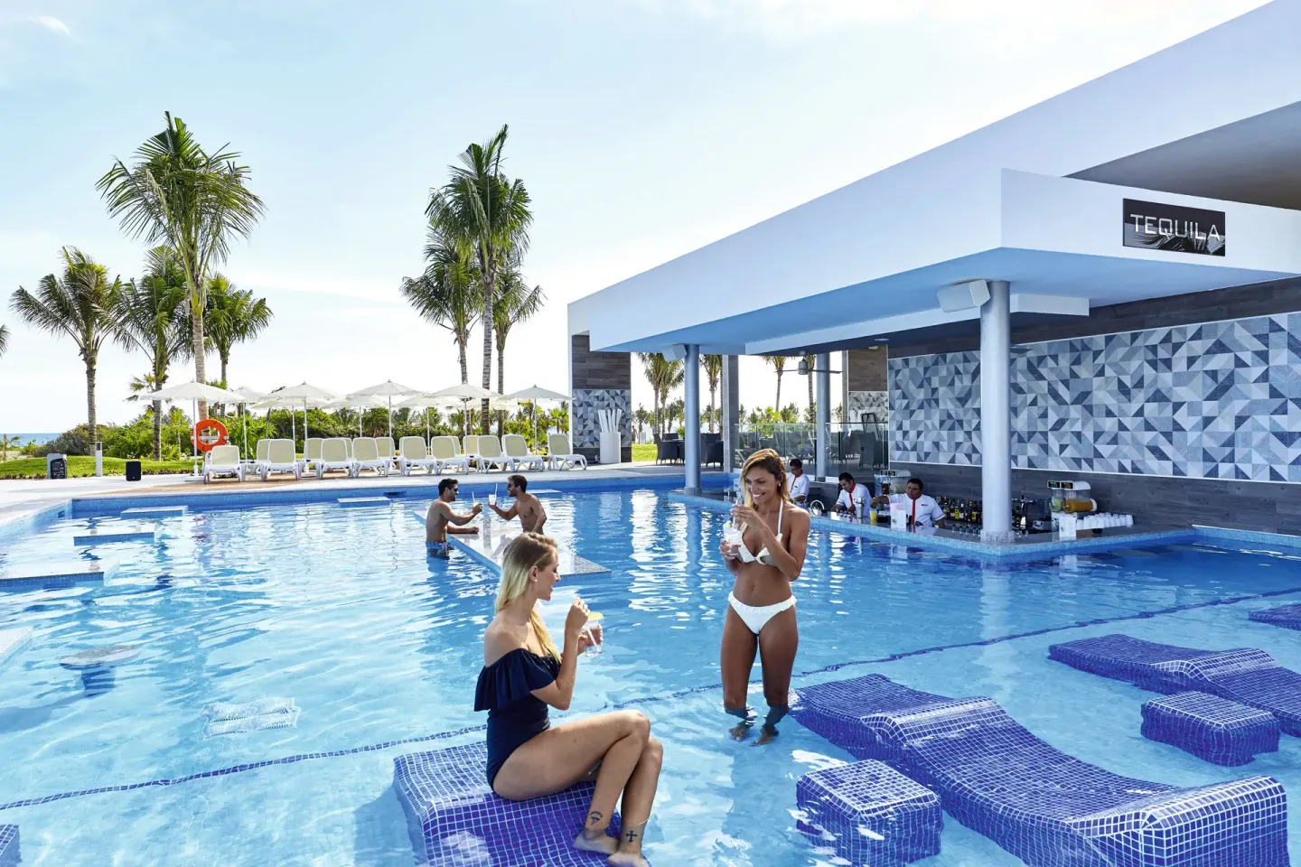 Swim-up pool bar and loungers in the water at Hotel Riu Dunamar.
