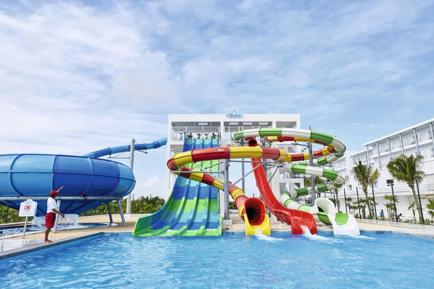 Colorful waterslides emptying into a pool at Hotel Riu Dunamar.