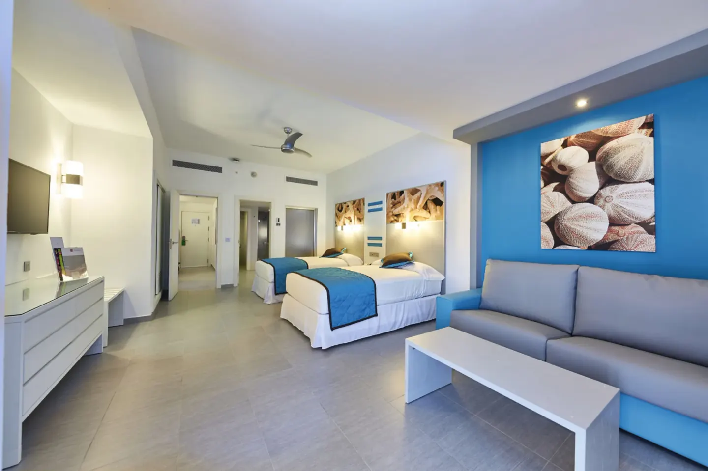 Family Suite living and bedroom area with two beds and sofa at Hotel Riu Dunamar.